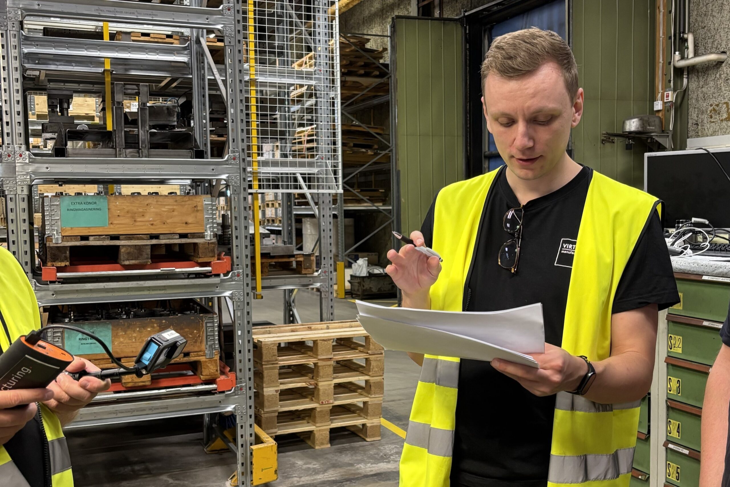 Produktionsingenjör i en produktionsmiljö som observerar arbetsflöden och identifierar förbättringsmöjligheter.